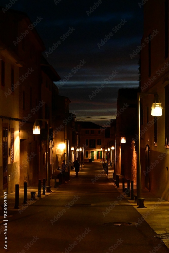 Nocturnidad Urbana: Una Calle Iluminada por Faroles Brinda una Atmosfera Encantadora y Serena en la Noche