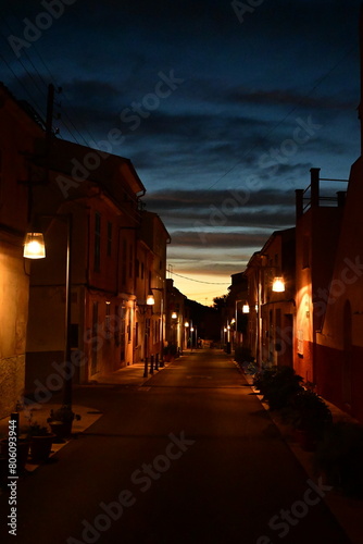 Nocturnidad Urbana: Una Calle Iluminada por Faroles Brinda una Atmosfera Encantadora y Serena en la Noche photo
