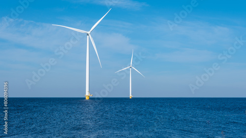 Two majestic wind turbines stand tall in the vast ocean, capturing the power of the wind and generating renewable energy for the Netherlands © Fokke Baarssen