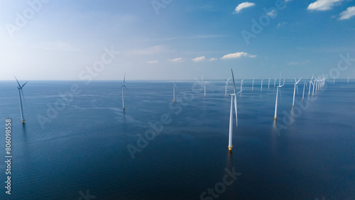 A group of wind turbines, sleek and modern, dance gracefully on the ocean waves, harnessing the power of the wind in Flevoland, Netherlands © Fokke Baarssen