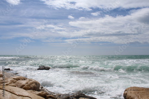 Fototapeta Naklejka Na Ścianę i Meble -  travel, sea wave on rocks against cloudy sky, sea coast with waves, waves on the beach, natural background texture of sea sky and stones