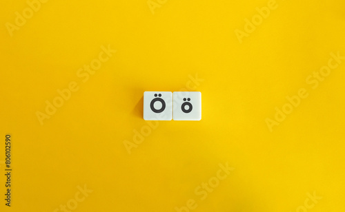 Capital and Small Letter Ö. Uppercase and Lowercase Letter. Concept of Learning Alphabet. Text on Block Letter Tiles against Yellow Orange Background. photo