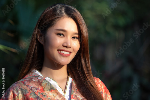 Portrait of beautiful young Asian woman smiling happily, wearing a kimono and looking at camera. Japanese traditional clothes.