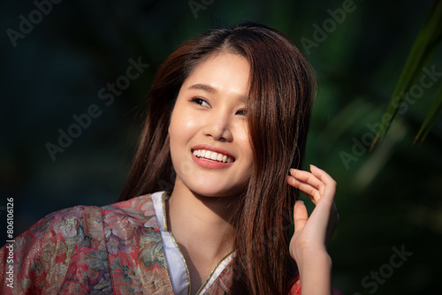Portrait of beautiful young Asian woman smiling happily, wearing a kimono. Japanese traditional clothes.