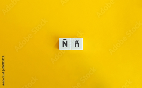 Capital and Small Letter ñ. Uppercase and Lowercase Letter. Concept of Learning Alphabet. Text on Block Letter Tiles against Yellow Orange Background photo