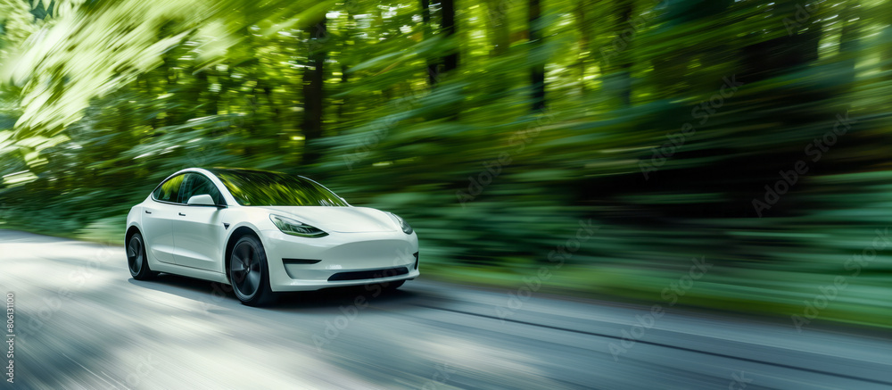 White electric car moving on the road against a green foliage in the blur. Copy space. Motion blur. Shallow depth of field White electric car moving on the road against a green foliage in the blur. Copy space. Motion blur. Shallow depth of field