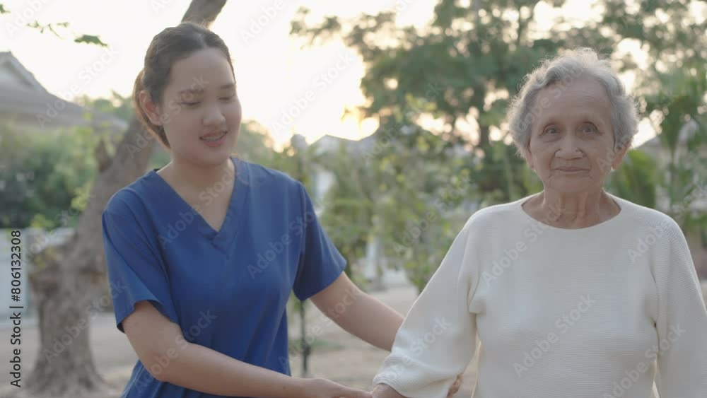 Young nurse and elderly asian senior woman on wheelchair, Asian careful caregiver and patient, Nurse gives a pep talk to an elderly female patient in the garden in the evening. Health insurance. Young nurse and elderly asian senior woman on wheelchair, Asian careful caregiver and patient, Nurse gives a pep talk to an elderly female patient in the garden in the evening. Health insurance.