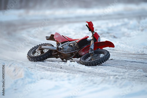 Fallen motorcycle in snow covered landscape photo