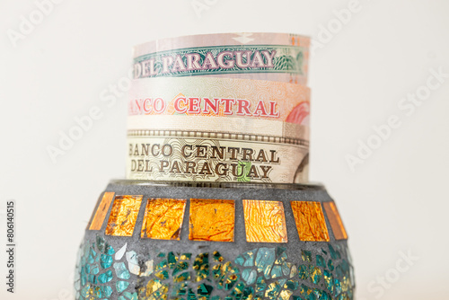 Paraguay money, banknotes sticking out from a decorative bowl, Financial concept, Financial savings of Paraguayans photo