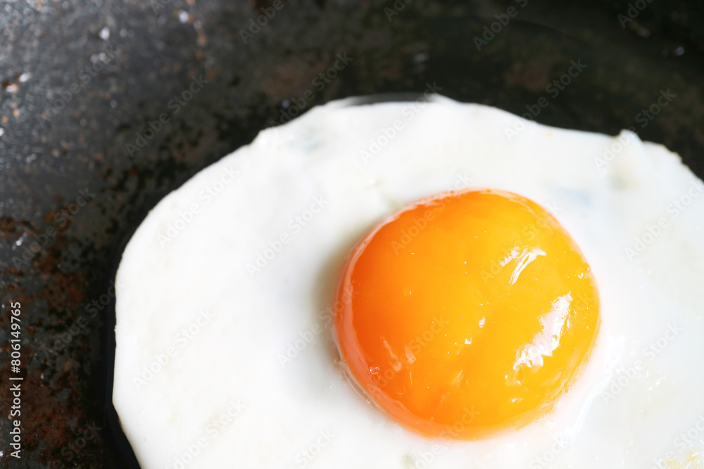 Closeup of a sunny side up egg being fried in a pan Closeup of a sunny side up egg being fried in a pan