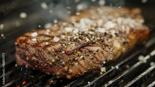 A steak being seasoned with sea salt and black pepper before grilling, showcasing the simplicity of classic seasoning.