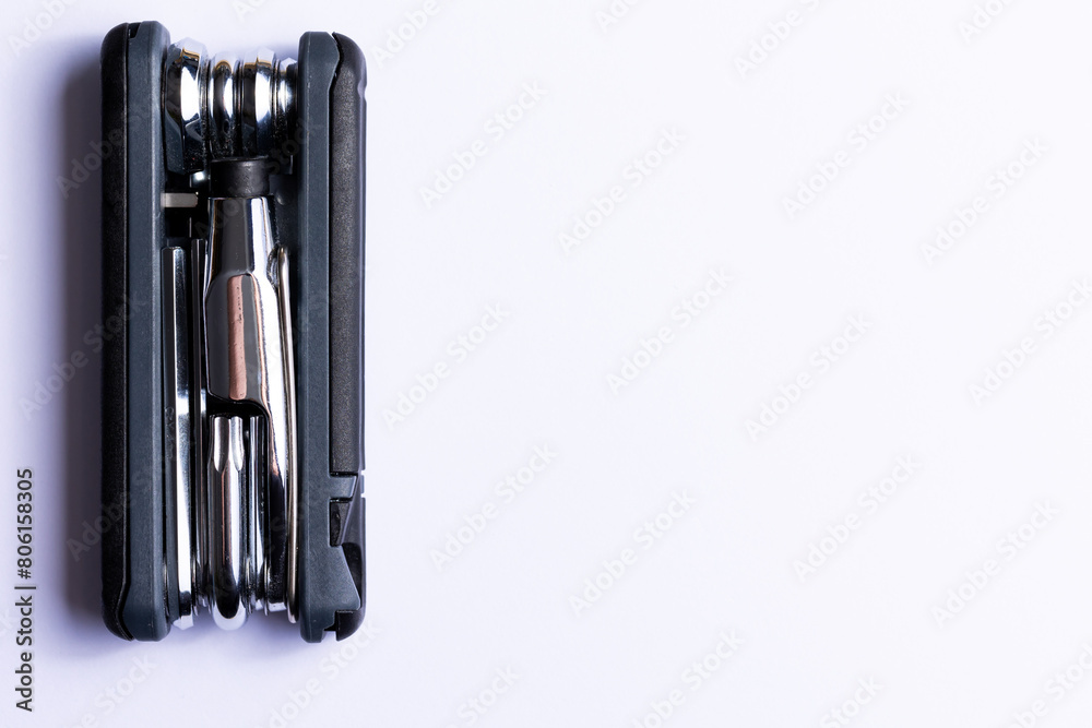 Black bicycle multifunctional multitool unfolded on a white background. Chrome steel tools. Tools for bicycle self-repairing .