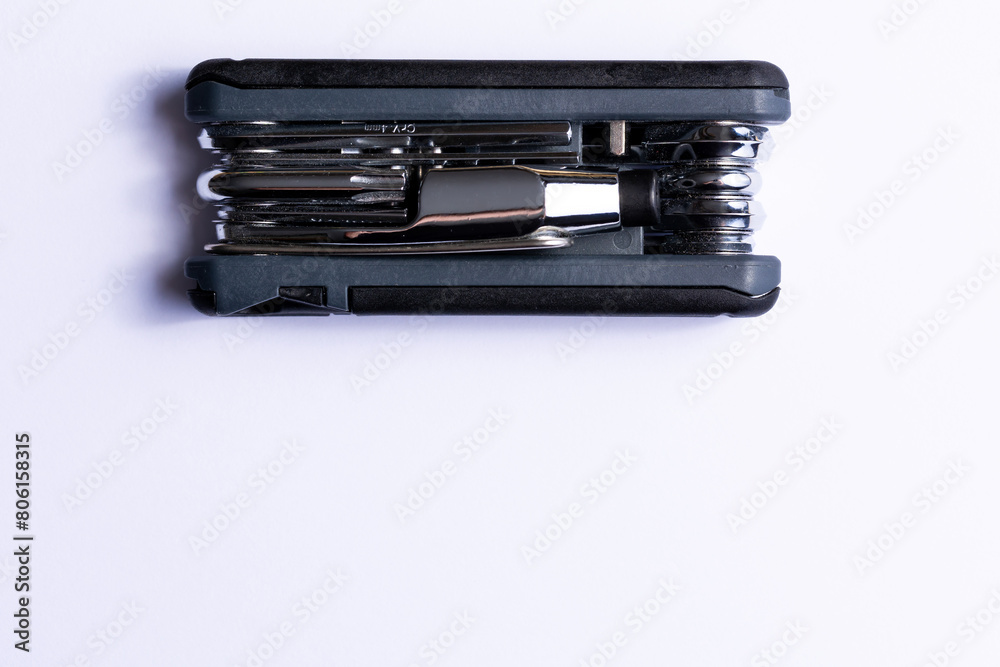 Black bicycle multifunctional multitool unfolded on a white background. Chrome steel tools. Tools for bicycle self-repairing .
