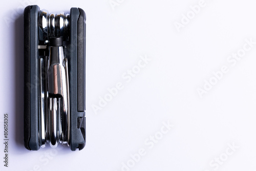 Obraz na płótnie Black bicycle multifunctional multitool unfolded on a white background. Chrome steel tools. Tools for bicycle self-repairing . w salonie