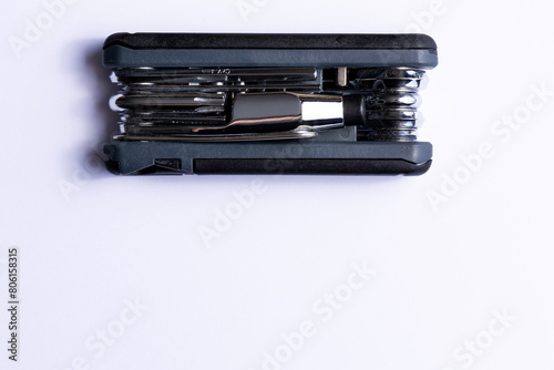 Obraz na płótnie Black bicycle multifunctional multitool unfolded on a white background. Chrome steel tools. Tools for bicycle self-repairing . w salonie