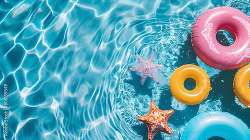 Summer seasonal background design with copy-space for text at center. Template for summer with vivid blue swimming pool surface and colorful pool rings. photo