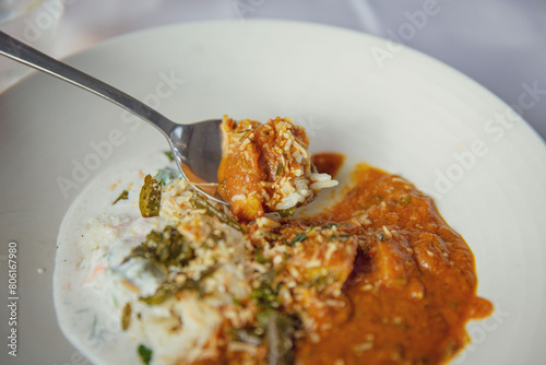 Enjoying a Sumptuous Indian Meal: A Curry of Either Lamb or Chicken Served with Basmati Rice and Raita on a Pristine White Plate