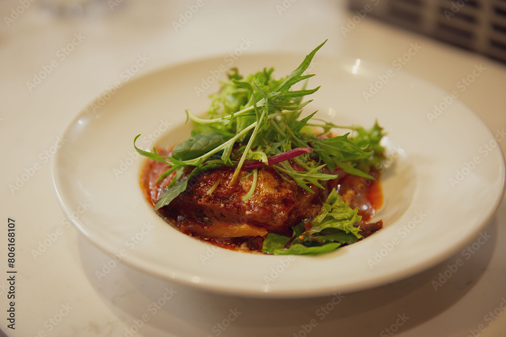 Savory Lasagna Layered with Melted Cheese, Served with Fresh Greens in White Ceramic Bowl on a Marble Tabletop Savory Lasagna Layered with Melted Cheese, Served with Fresh Greens in White Ceramic Bowl on a Marble Tabletop