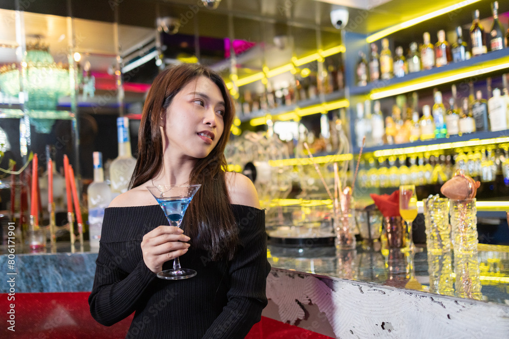 Confident Woman with Blue Cocktail at Stylish Bar