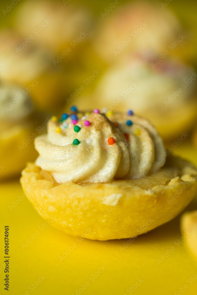 Fototapeta premium Macro photo of mini lemon pie on yellow background.