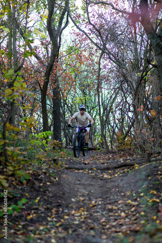 A mountain biker rides a challenging trail through the forest.