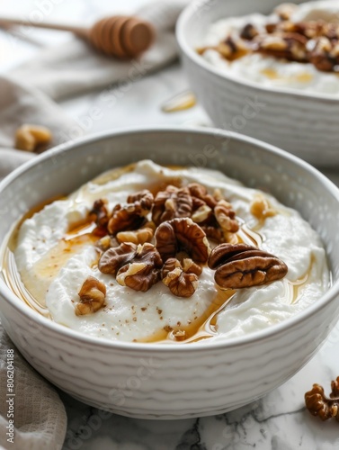 Close-up of creamy Greek yogurt drizzled with golden honey and topped with crunchy walnuts, a delicious and nutritious start to the day, on a marbled surface.
