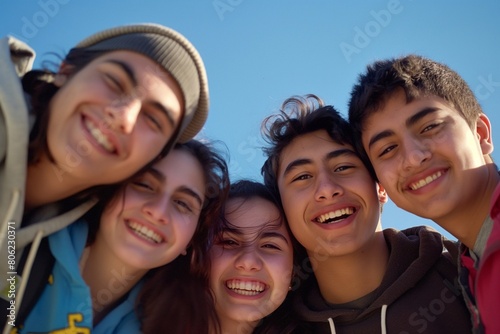 A group of friends smiling and posing for the camera, capturing their joyful expressions. The background is clear with a blue sky. an atmosphere of happiness among young people. generative AI