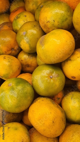 Close up pile of tasty fresh oranges sold at the market as a background.