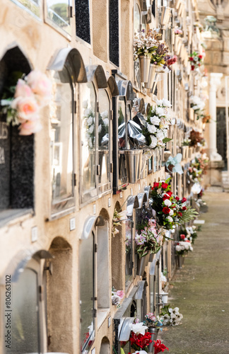 Blumenvasen an einer Wand aus Gräbern auf einem Friedhof in Barcelona, Spanien