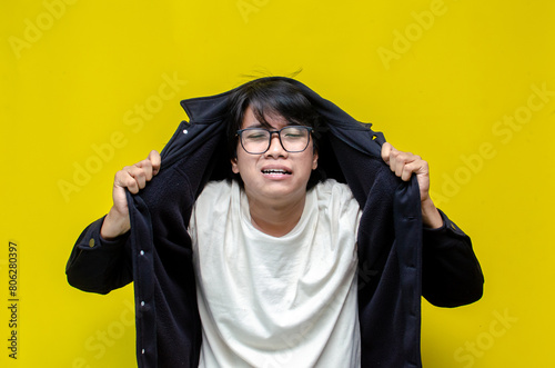 asian man looks depressed and messed up. Irritated man bites lips and scratches head. stressed over work concept.
