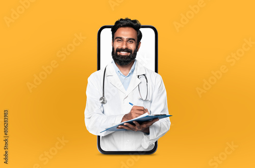 Smiling young eastern man doctor with a clipboard, presented within a smartphone frame, illustrating a user-friendly telehealth app interface