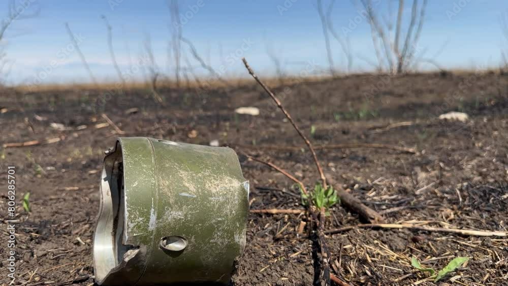 An electronic control part from rocket munition lies among burnt earth in forest plantation with burnt trees. War in Ukraine An electronic control part from rocket munition lies among burnt earth in forest plantation with burnt trees. War in Ukraine