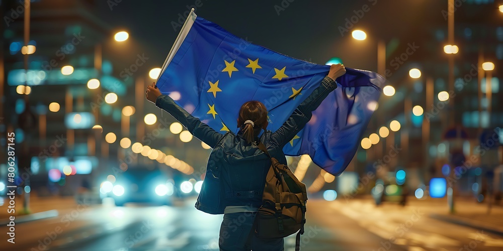 A person wearing a mask and holding two EU flags over their head. A person wearing a mask and holding two EU flags over their head.