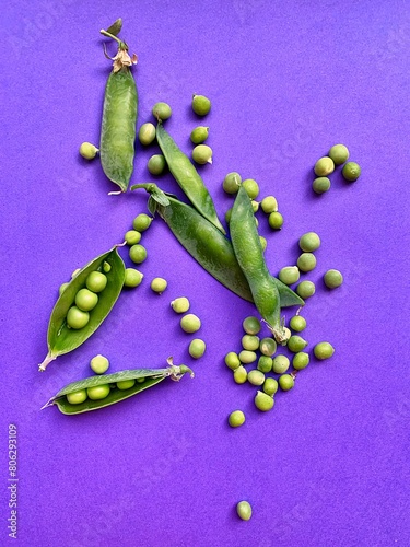 green peas, peas on a purple background, peeled peas in shell, fresh vegetables