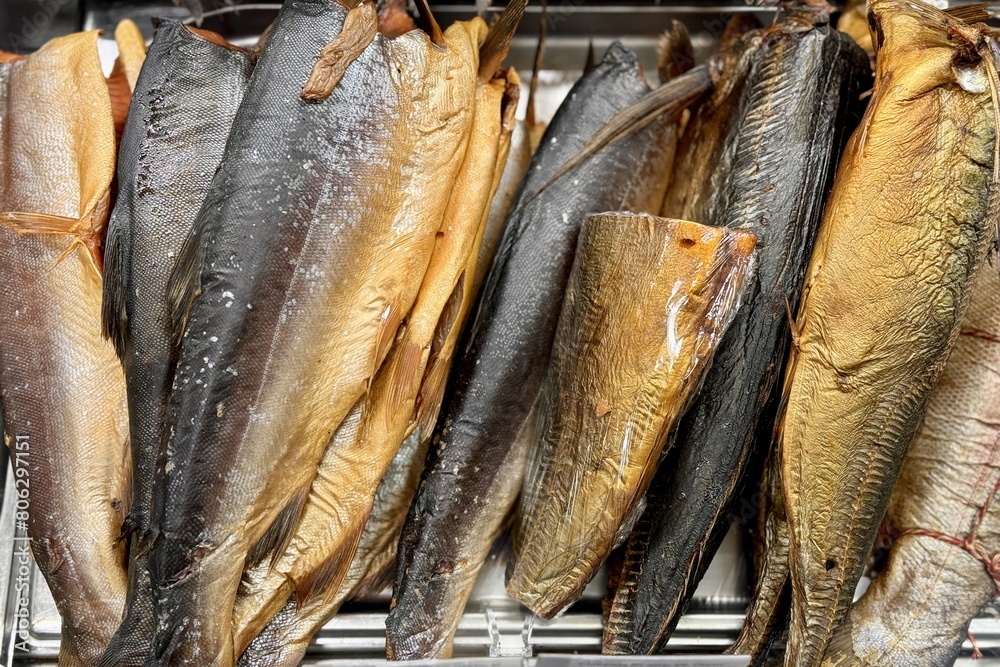 Fragment of cold smoked mackerel and Atlantic salmon on a substrate for sale in the supermarket. Close-up Fragment of cold smoked mackerel and Atlantic salmon on a substrate for sale in the supermarket. Close-up