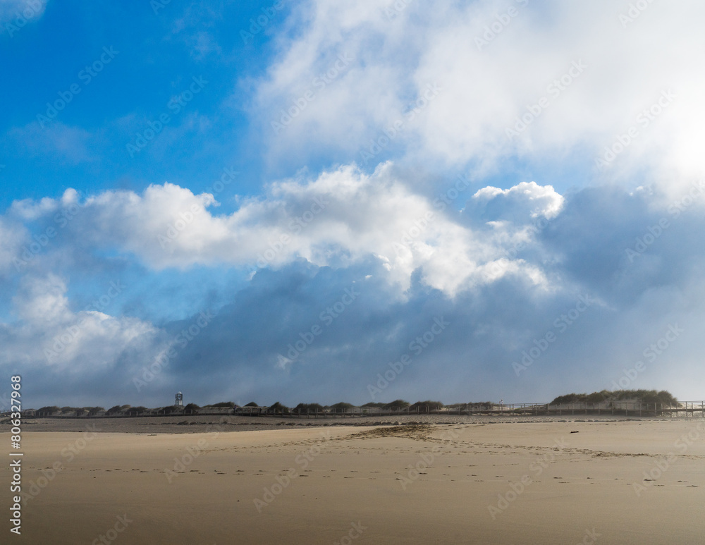 Blue sky and approaching rain clouds over an empty sandy beach on the ocean shore. Blue sky and approaching rain clouds over an empty sandy beach on the ocean shore.