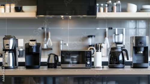 An array of black and stainless steel kitchen appliances lined up against a tiled backdrop showcasing modern culinary tools