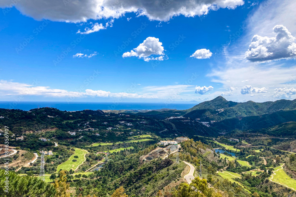 Fototapeta premium Clouds on blue sky over golf fields, Marbella, Spain