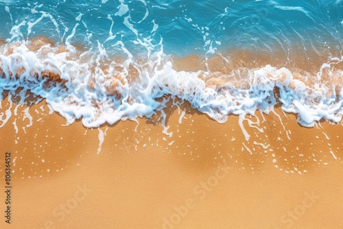Electric blue waves crashing on sandy shore from an aerial view
