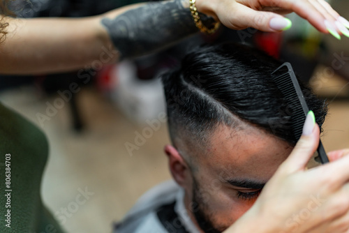 Detailed shot of a barber skillfully shaping a male client's hair with a razor and comb, focusing on ultra-precise cuts and style within the sophisticated setting of the barber shop.