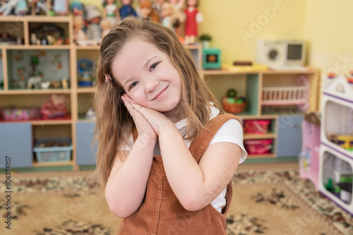 happy girl playing in kindergarten in group with toys, constructor