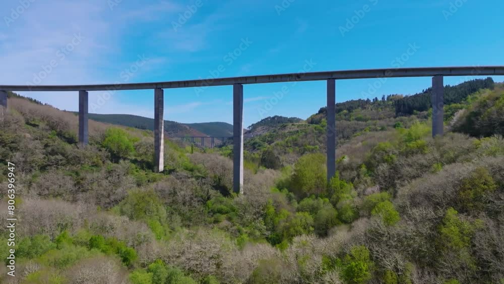 Aerial shot of Elevated Highway Over the Dense Forest in Becerrea, Lugo, Spain on a sunny day Aerial shot of Elevated Highway Over the Dense Forest in Becerrea, Lugo, Spain on a sunny day