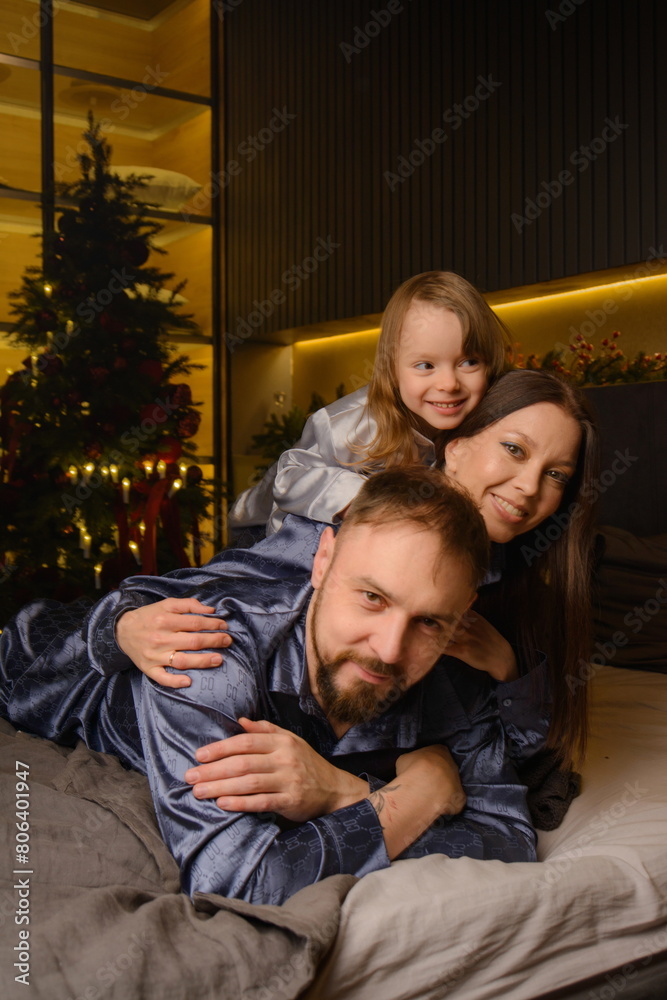 A happy family poses in pajamas in New Year's locations. A happy family poses in pajamas in New Year's locations.