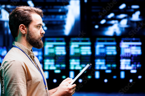 IT developer setting up high tech data center firewalls, intrusion detection systems and doing security updates. Cybersecurity employee preventing hacking, malware, and DDoS attacks in server hub photo