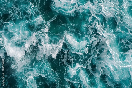 From above aerial view of turquoise ocean water with splashes and foam for abstract natural background and texture