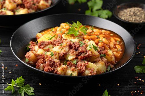 Corned beef hash with potatoes and beans in tomato sauce.