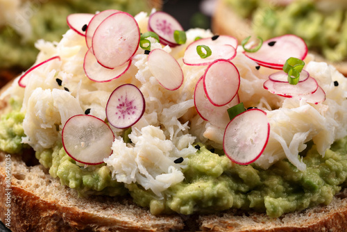 Crab meat and smashed avocado and radishes Sourdough bread toasts © grinchh