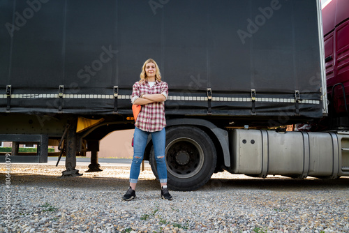 Foto Confident young woman truck driver standing proudly with her arms crossed in fro