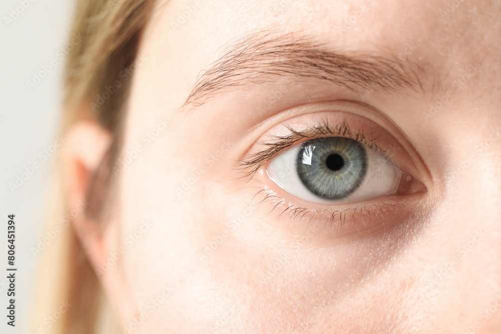 Fototapeta premium Macro photo of woman with beautiful eyes on light background