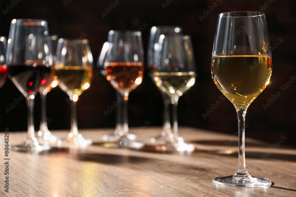 Different tasty wines in glasses on wooden table Different tasty wines in glasses on wooden table
